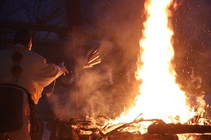 護摩木を日に投げ入れる祭典関係者