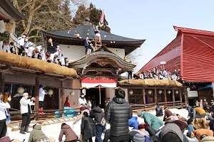 福餅撒与する様子と餅を拾う来場者