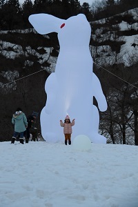 ウサギのバルーンの前で写真を撮る子ども