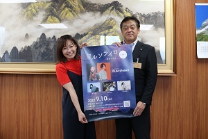 イベントのポスターをもって記念写真を撮る林市長とツネイさん