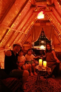 ライトアップされた小屋の中で写真を撮る家族