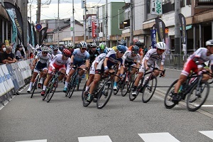 商店街を駆け抜けるレース中の選手たち