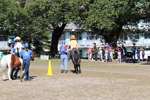 乗馬をする児童を応援する児童