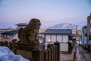 夕暮れの山並みと狛犬