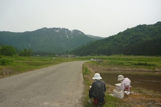 山を写生している人の写真