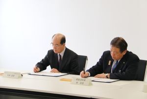協定書にサインをする今泉社長と林市長